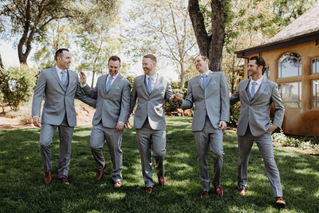 Groomsman walking and laughing together in the grass at Helwig Winery. Liz Koston Photography.