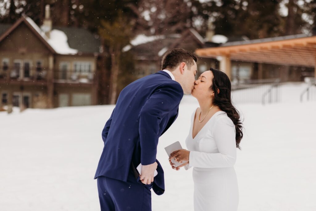 Bride and groom kiss as it snows in Lake Tahoe before their elopement. Liz Koston Photography.