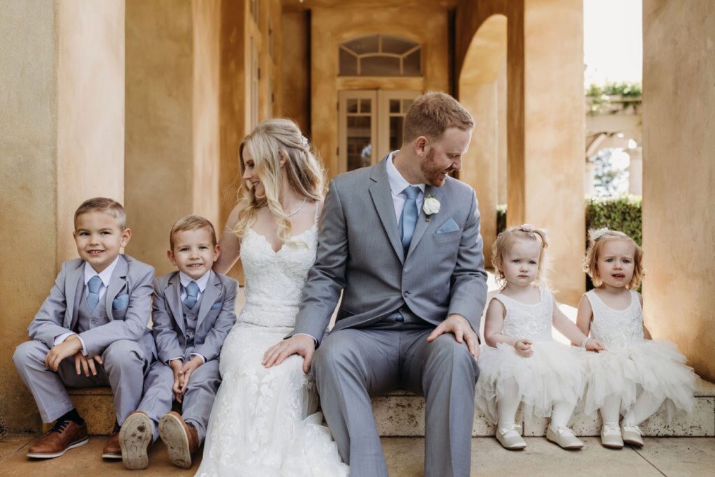 Bride and groom take a family photo with their two boys and two girls. Liz Koston Photography.