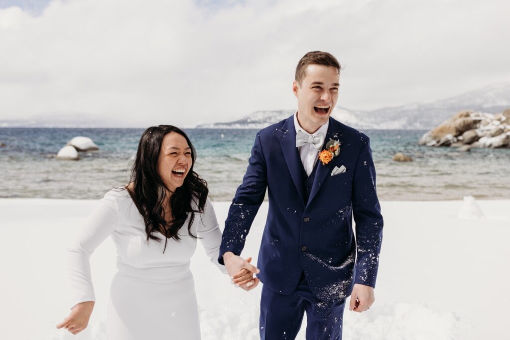 Bride and groom throw snow and smile after their Lake Tahoe winter elopement. Liz Koston Photography.